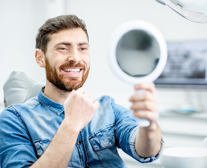 Dental patient looking at his smile in a mirror