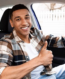 Man smiles in car