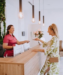 Dental receptionist assists smiling patient