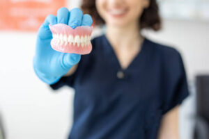 Close up of lab technician holding dentures